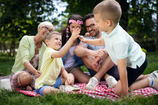 Happy multi generation family enjoying picnic in a park - Foto, afbeelding