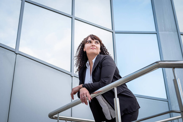 outdoor portrait of a confident business woman standing outdoors looking at the sky - Photo, Image