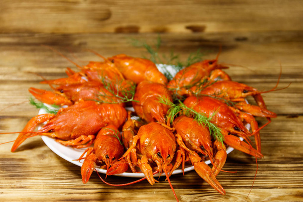 Boiled crayfish in plate on wooden table - Photo, Image