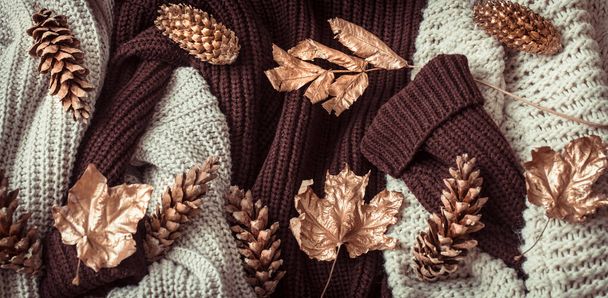 Őszi háttér hangulatos pulóverek és arany levelek . - Fotó, kép