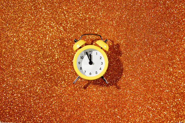 Alarm clock on glitter background, New Year countdown. - 写真・画像