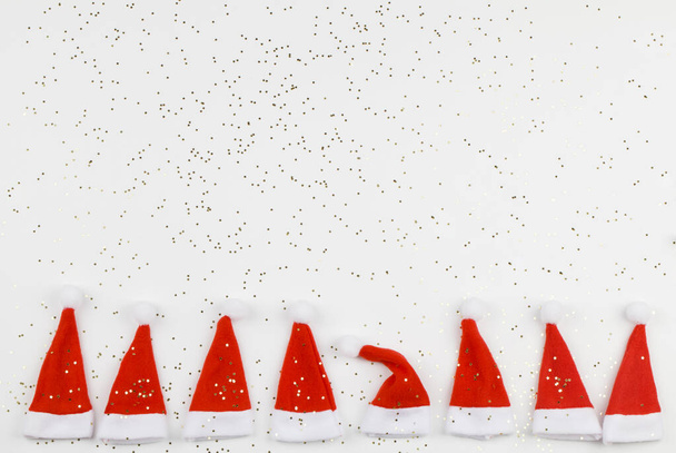 Beyaz arka planda küçük yıldızlı Noel Baba şapkaları. Noel ve yeni yıl kutlaması. Noel konsepti. Farklılık kavramı - Fotoğraf, Görsel