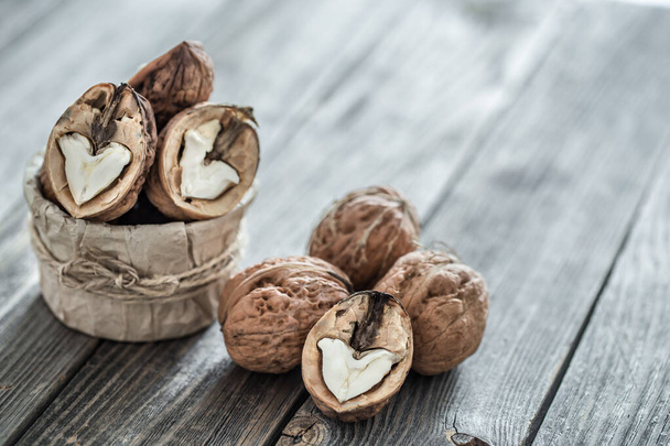 Walnut in open form on a wooden background, close-up . - Photo, Image