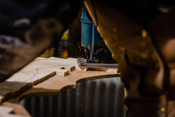 Carpenter using an electric jigsaw - Foto, Bild