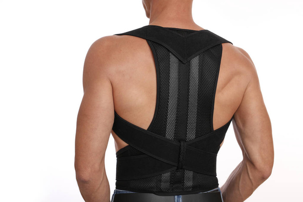 Attractive muscular man with posture corrector. Scoliosis, Kyphosis treatment - Foto, Bild