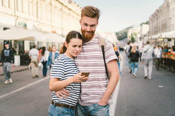 カップルの観光客が街や路上で携帯電話のGPSをコンサルティング。旅行中だスマートフォンのカップルのチェック場所。ライフスタイルのテクノロジー。スマートフォンのナビゲータシステムアプリを使って - 写真・画像