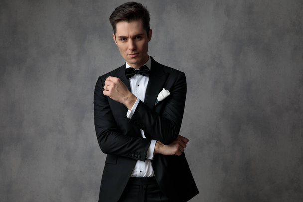 elegante uomo di moda che indossa smoking nero su sfondo grigio
 - Foto, immagini