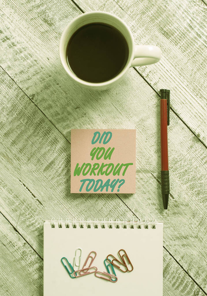 Conceptual hand writing showing Did You Workout Today. Business photo showcasing asking if made session physical exercise Stationary placed next to a coffee cup above wooden table. - Photo, Image