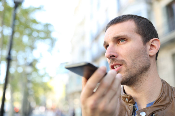 Volwassen man met spraakherkenning aan de telefoon om een bericht te sturen - Foto, afbeelding