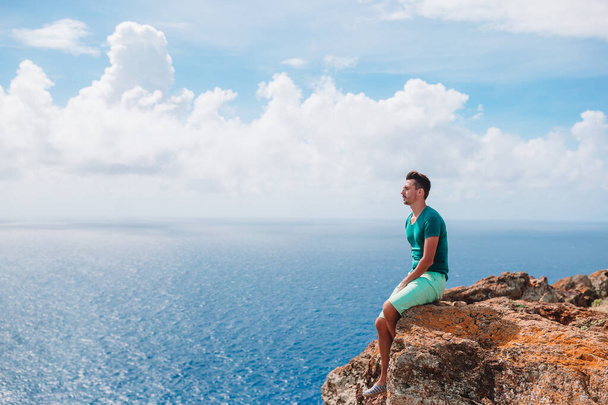 Jongeman geniet van een adembenemend uitzicht op het prachtige landschap - Foto, afbeelding