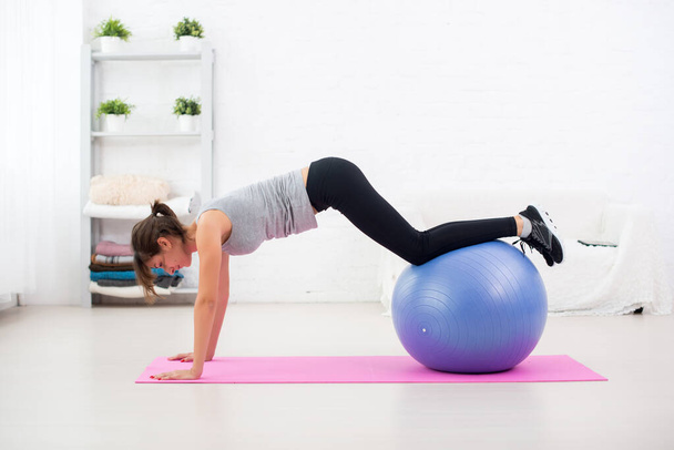 Sportieve vrouw doen stretching fitness oefening op bal - Foto, afbeelding