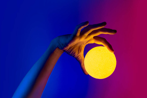 Homme tenant la forme de lune jaune sphère illuminée
 - Photo, image
