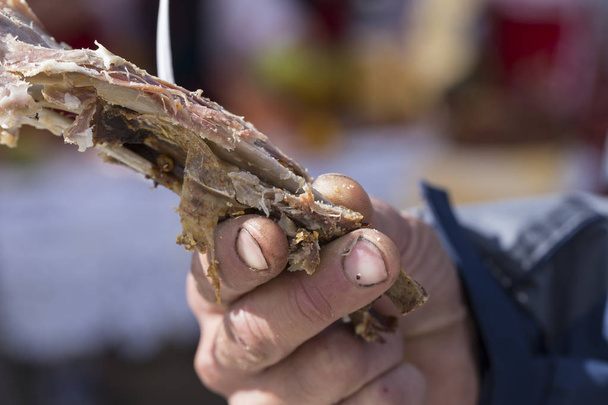 Ribs of baked lamb in the hand of a peasant. - Photo, Image