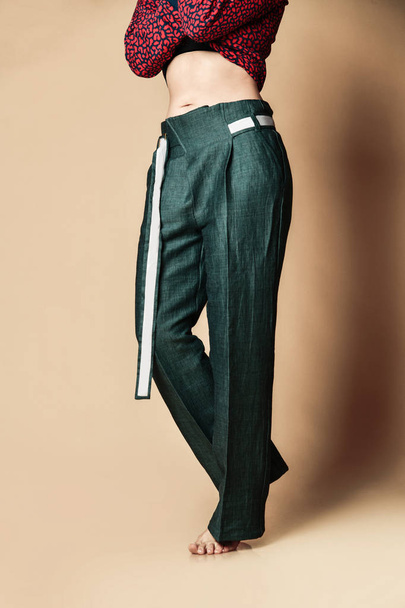 新しいデザインの女性の緑のパンツカジュアルな女の子のアパレルはベージュ上のベルト  - 写真・画像