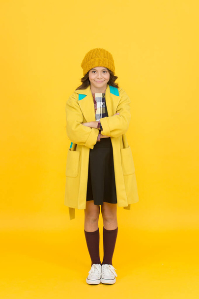 Alltag ist Modenschau. kleines Schulkind in Herbstmode gelber Hintergrund. Kleines modisches Modell mit niedlichem Mode-Look. zurück zur Schule. Studie zur Mode - Foto, Bild