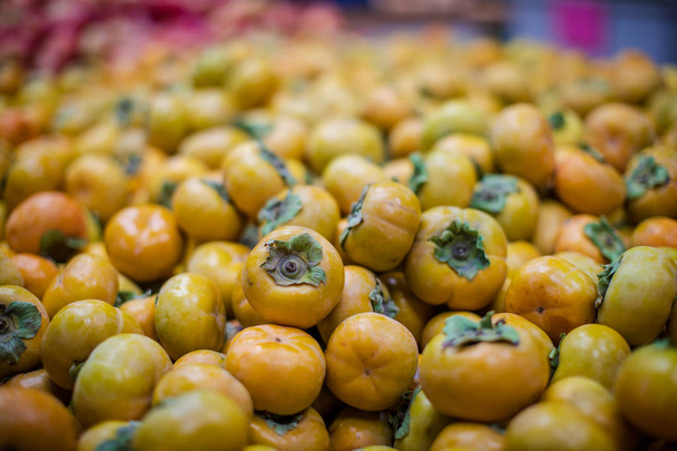 fresh autumn persimmon in a market - Photo, Image