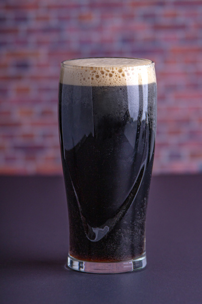 Un vaso de cerveza corpulento seco irlandés oscuro Guinness que se originó en th
 - Foto, imagen