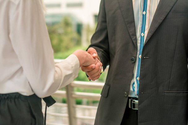 ビジネスマンやビジネスマンは握手をし議論し、共同で立つ - 写真・画像