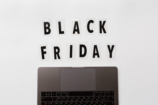 Creative promotion composition Black friday text and laptop on white background. Flat lay, top view, overhead, mockup, template. Minimal abstract background. Online shopping, sale, promo. Web banner - Foto, immagini