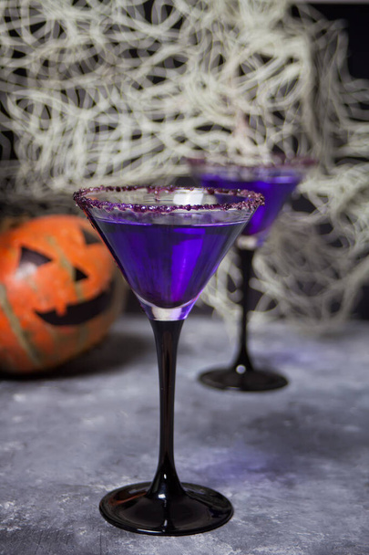 Two glasses with purple cocktail, pumpkin for Halloween party on the dark background - Photo, image