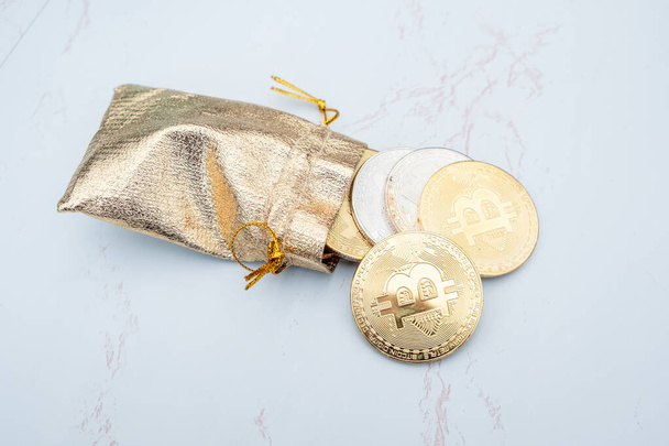 Bunch of Crypto currency coins in a golden moneybag with focus on BTC Bitcoin - Zdjęcie, obraz