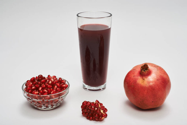 pomegranate fruits, seeds and juice on white background. - 写真・画像