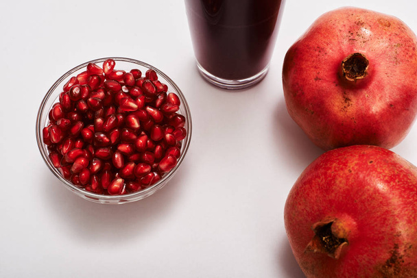 pomegranate fruits, seeds and juice on white background. - 写真・画像