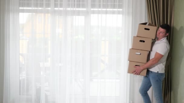 Mann trägt große Kisten mit Habseligkeiten in neues Haus - Filmmaterial, Video