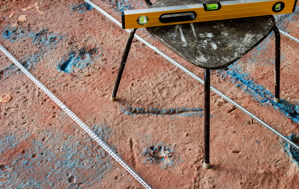  Installazione di una guida per il massetto di cemento. Strumento di livello sulla sedia
. - Foto, immagini
