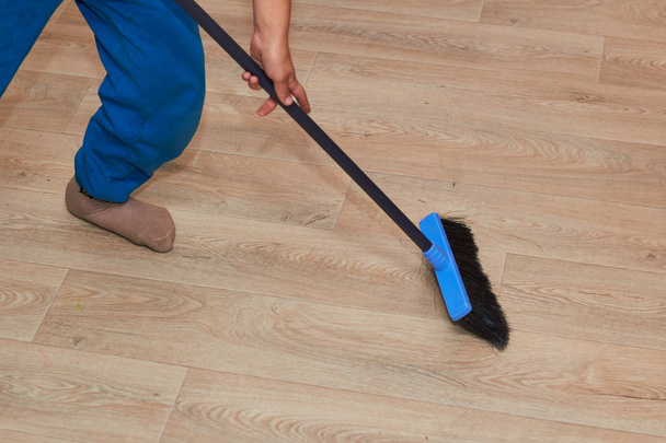 Sweep the floor with a broom feet, broom, floor. - Zdjęcie, obraz