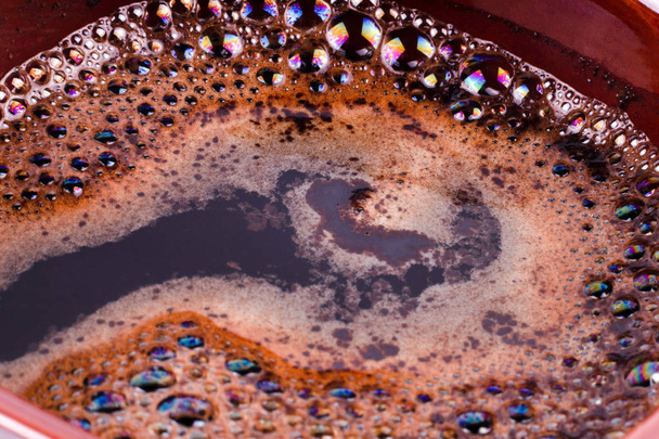 Vista de perto de um café aromático escuro com espuma no topo
 - Foto, Imagem