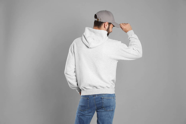 Young man in sweater on grey background. Mock up for design - Valokuva, kuva