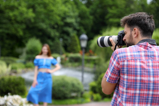 Photographer taking photo of woman with professional camera in park - Valokuva, kuva