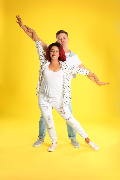 Beautiful lovely couple dancing on yellow background - Фото, изображение