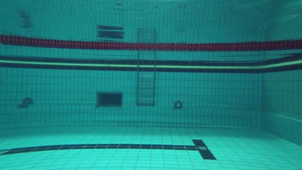 professional swimming in pool, Sports woman plunges underwater while float training at Poolside - Footage, Video