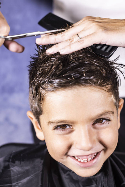Hermoso chico consiguiendo un corte de pelo con tijeras
 - Foto, Imagen
