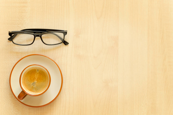 Desktop with notebook, pencil, eyeglasses and coffee cup. - Foto, afbeelding