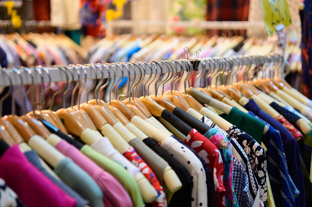 Vestiti da donna colorati su appendini in un negozio al dettaglio - Foto, immagini