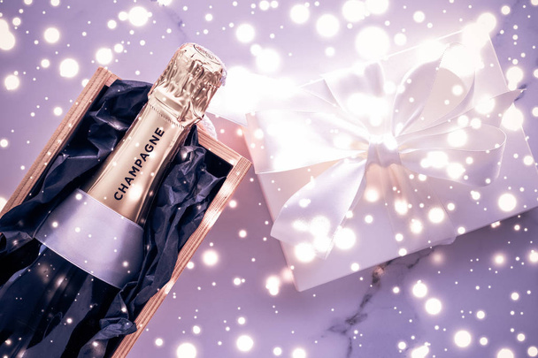 Botella de champán y caja de regalo en brillo de vacaciones púrpura, New Yea
 - Foto, imagen