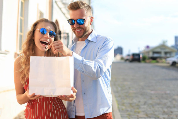 Young happy couple with shopping bags in the city - Foto, Imagem