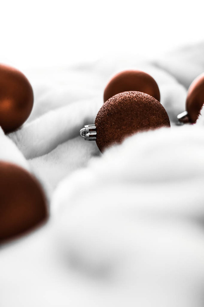 Bola de Navidad marrón chocolate sobre fondo de piel esponjosa blanca
,  - Foto, imagen