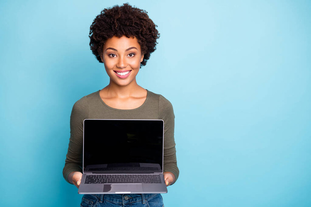 Photo of cheerful charming nice cute black woman demonstrating you new line of laptops with sales at once smiling toothily isolated over vivid color blue background - Foto, Imagem