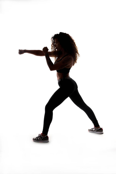 Chica haciendo ejercicios y tablas de gimnasia, entrenador personal, silueta negra sobre fondo blanco de un perfil de mujer, bien entrenado, cuerpo perfecto
 - Foto, imagen