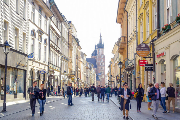 Tourists walking through Florianska street with St. Mary's Basilica church in background, the main streets in Krakow Old Town and one of the most famous streets of Krakow, Poland - Photo, Image
