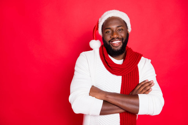 Portré pozitív vicces barna haj afro amerikai férfi keresztbe a kezét készen áll, hogy megünnepeljük újév karácsony ideje viseljen fehér pulóver sál elszigetelt felett piros színű háttér - Fotó, kép