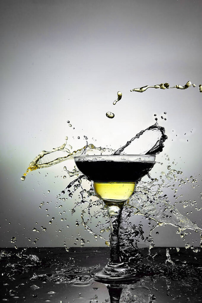 Стекло с голубым и желтым шампанским или коктейлем. Левитация
 - Фото, изображение