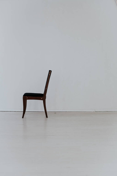 cadeira preta fica sozinha na sala branca
 - Foto, Imagem
