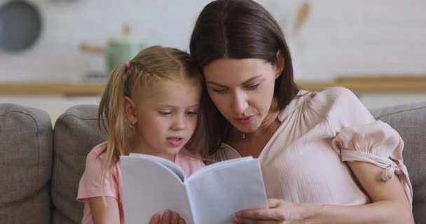 Happy family mom and kid daughter reading book at home - Footage, Video