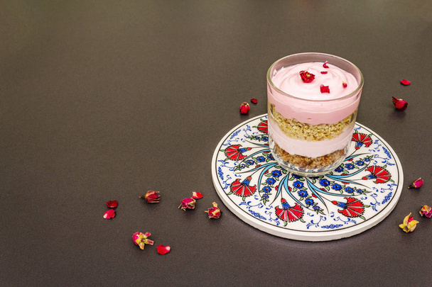 Sobremesa de creme delicada. Rosa comestível turca tradicional, pétalas de flores
 - Foto, Imagem