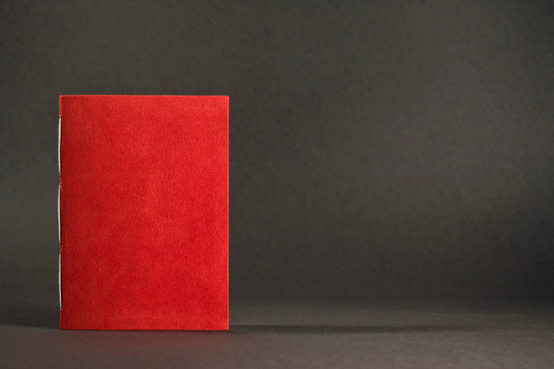 Маленькая книга ручной работы изолирована, закрытая красная повестка дня на сером фоне
 - Фото, изображение